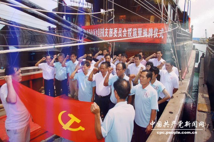 “科学发展 成就辉煌”图片展·党建·图为2011年6月,海南临高县委在北部湾渔船上为泽业南沙美济礁党支部举行授旗暨揭牌仪式