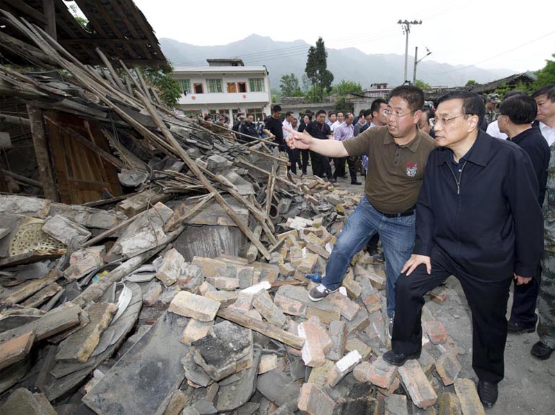2013年四川蘆山地震。李克強抵達地震災區指導抗震救災工作。圖為：李克強在受災嚴重的雙石鎮察看災情。