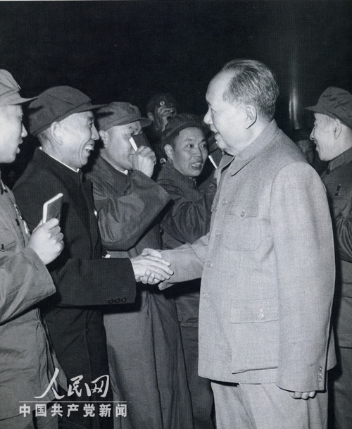 1969年國慶節毛澤東在天安門城樓上和王震握手。
