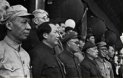 1949年10月1日，刘伯承（前排左三）等陪同毛泽东（前排左二）、刘少奇（前排左一）在天安门城楼上检阅游行队伍。
