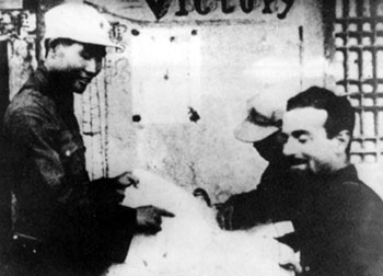 1936年8月12日，肖勁光（左）以紅29軍軍長的身份，在寧夏預旺堡西征紅軍司令部同美國記者埃德加·斯諾親切交談。　