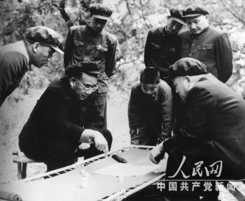 1953年，彭德怀与朱德在十三陵水库工地下棋。观棋者右一为邓小平。