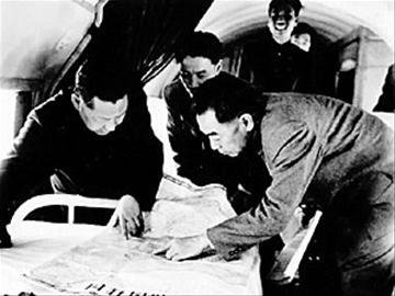 1958年4月，周恩來總理與習仲勛（左）在飛機上研究三門峽水庫建設資料。